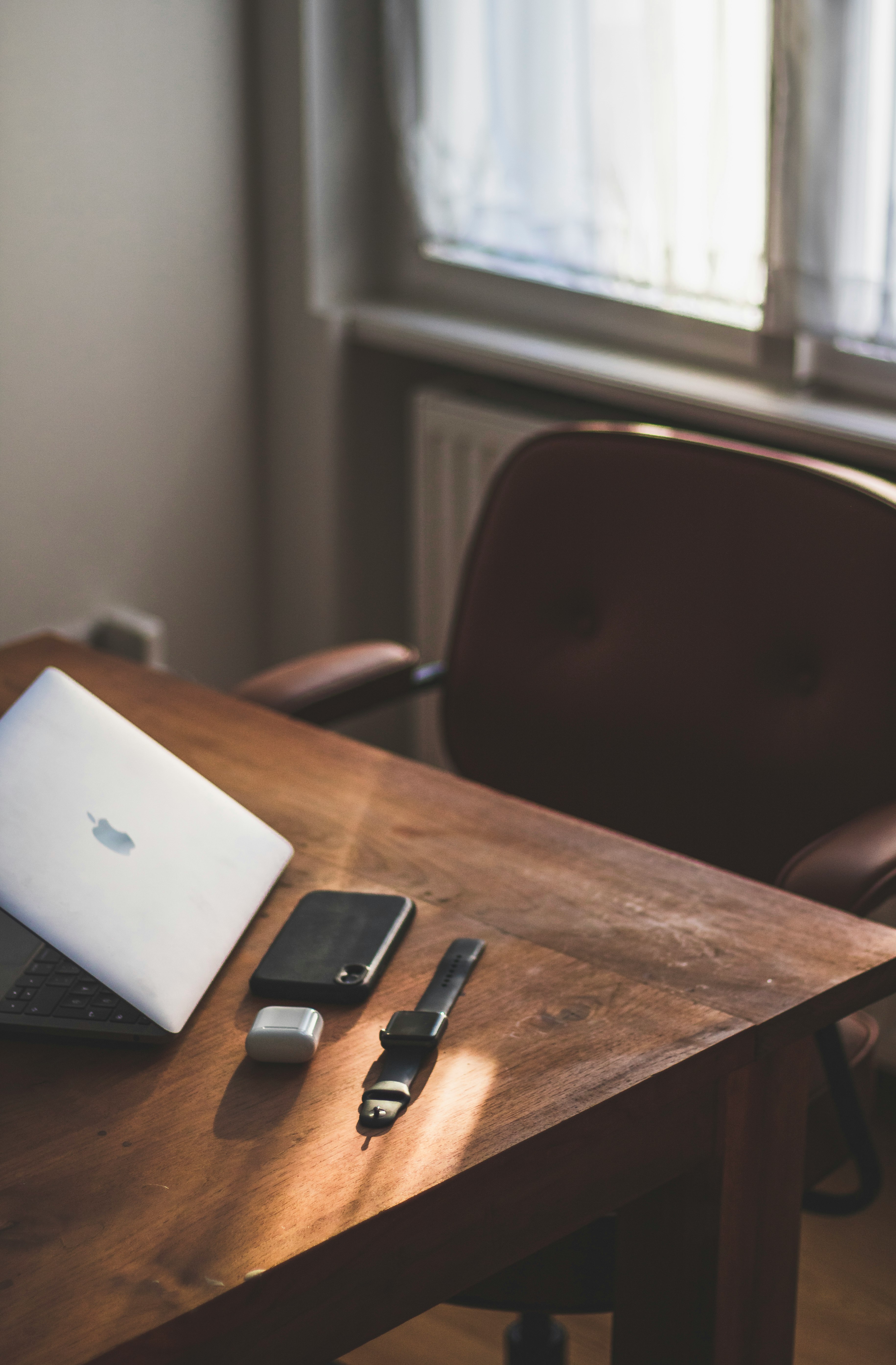 silver macbook on brown wooden table